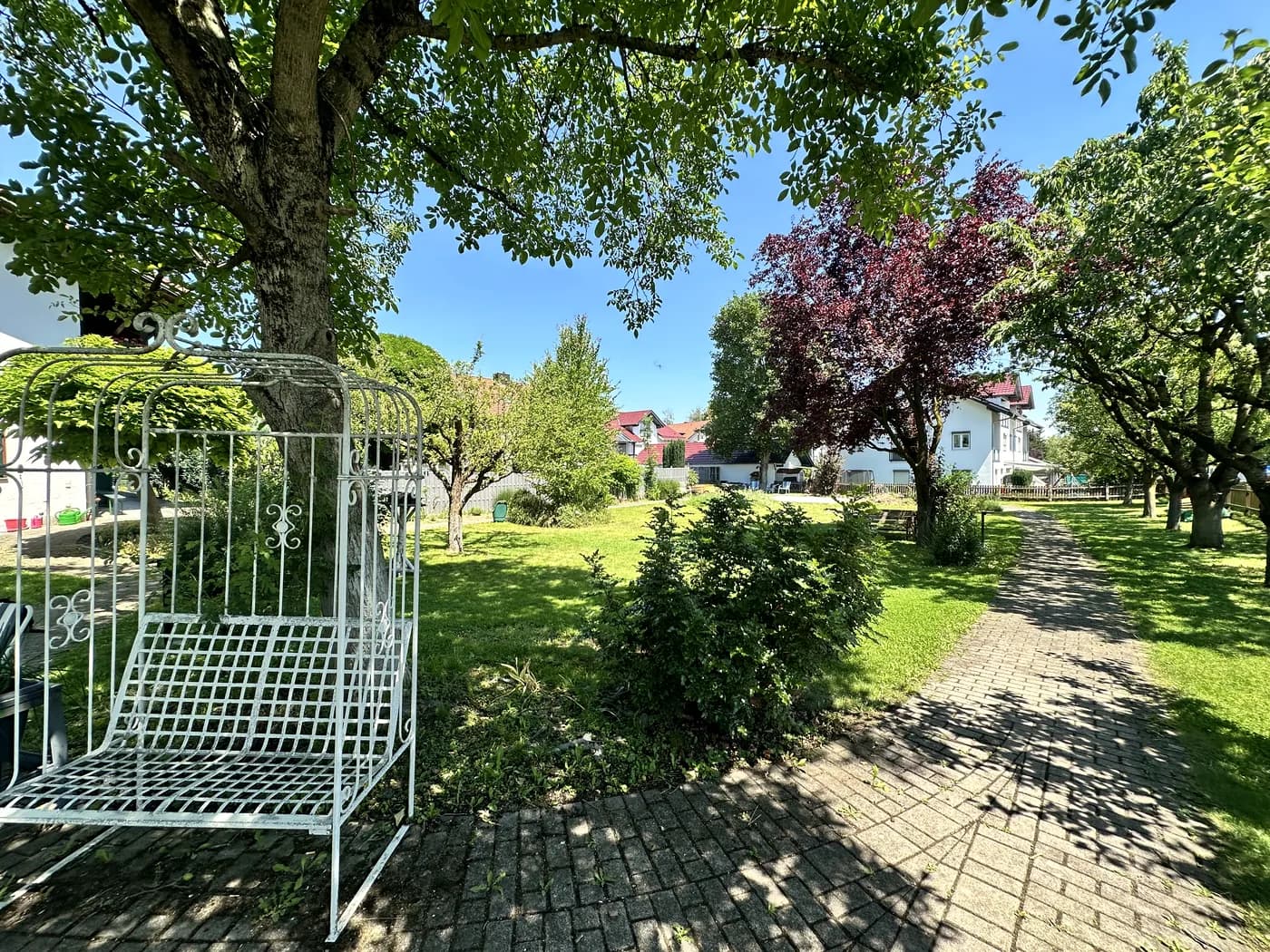 Gartenwege, Bäume und Sitzbereiche im Außenbereich des Seniorenpflegeheims