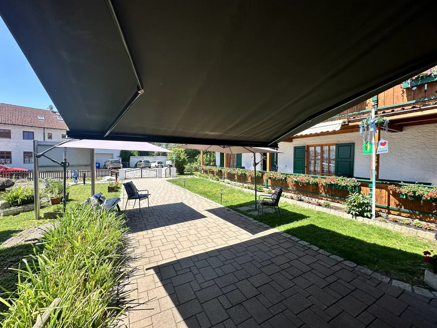 Geschützter Ruhebereich mit Wegen, Pflanzen und Blick auf das Haus