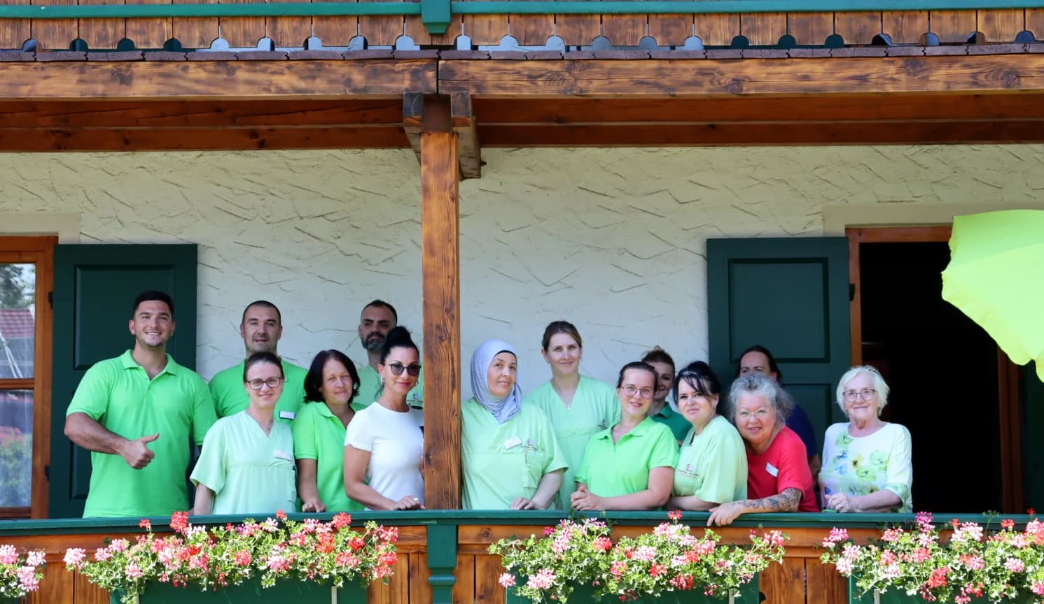 Team des Seniorenpflegeheims Maria Schnee auf dem blühenden Balkon